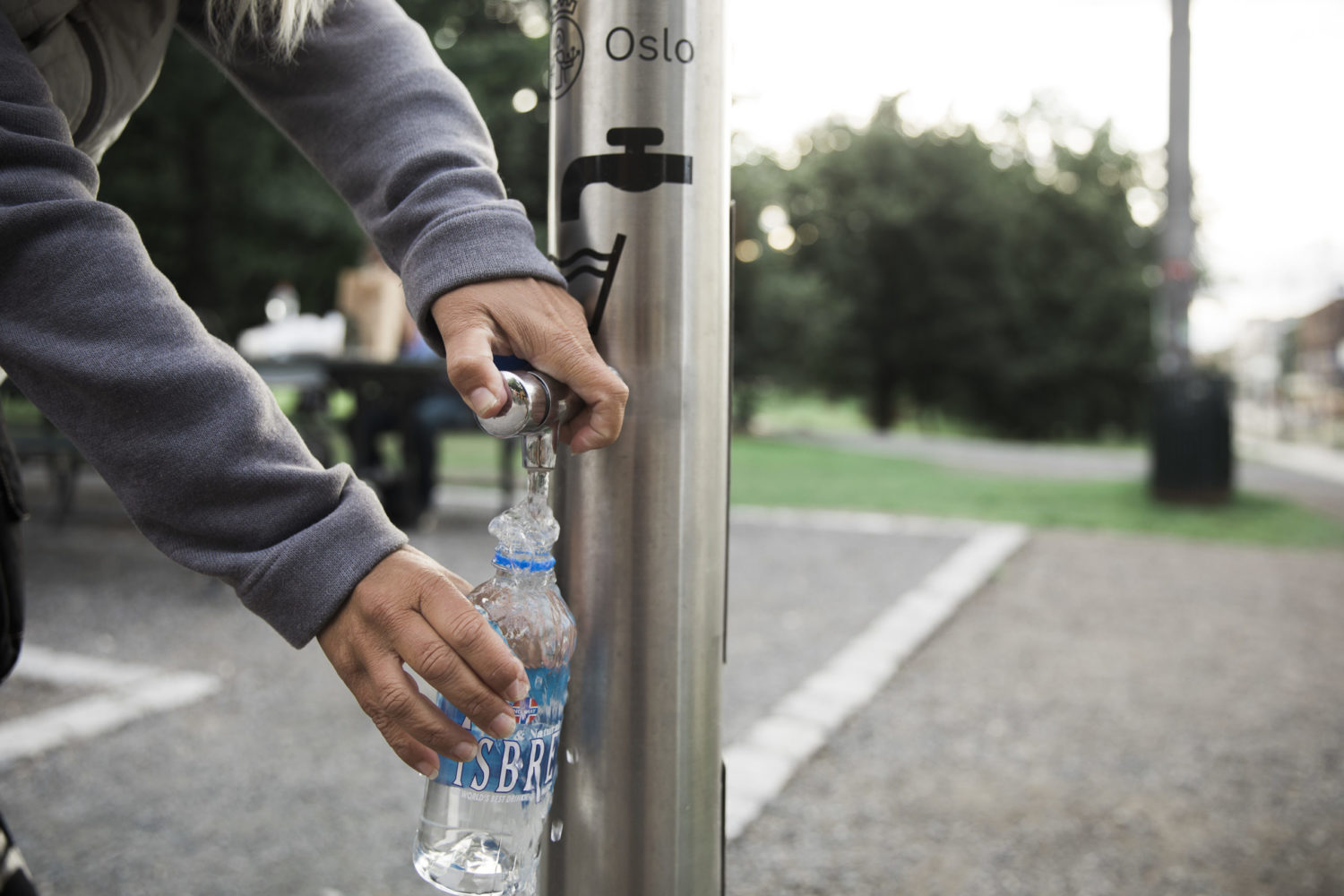 Oslo: Person filling up their water bottle from a fountain.