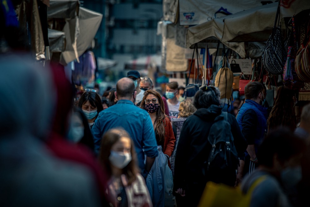 People wearing masks or face coverings outside in a busy market