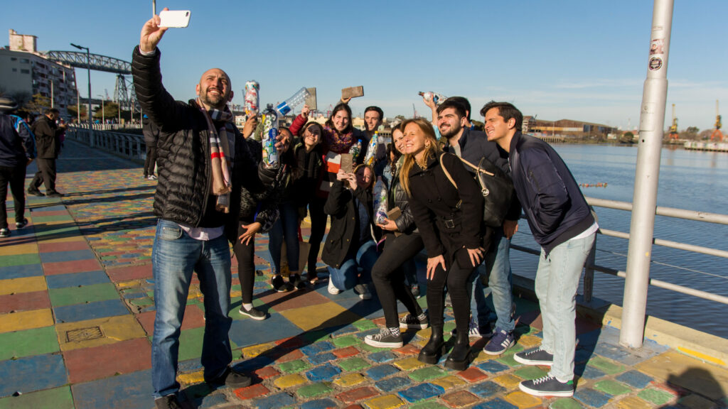 Young climate activists in Buenos Aires who took part in a day of awareness-raising on plastic waste take a selfie in front of a lake.
