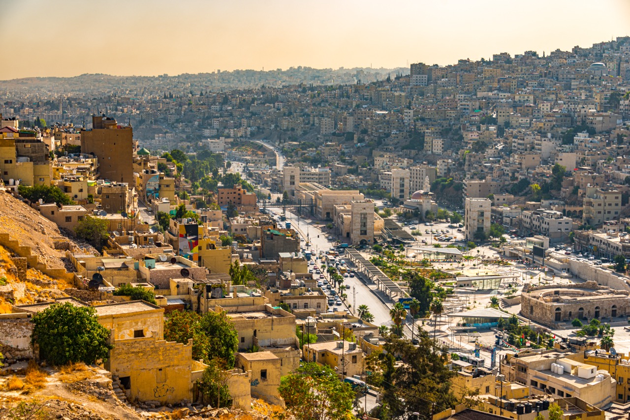 The panoramic view of the native architectural homes and buildings in Amman Citadel, Jordan, and the Abu Darwish Mosque sits on a hill surrounded by green trees over the skyline - October 14, 2015